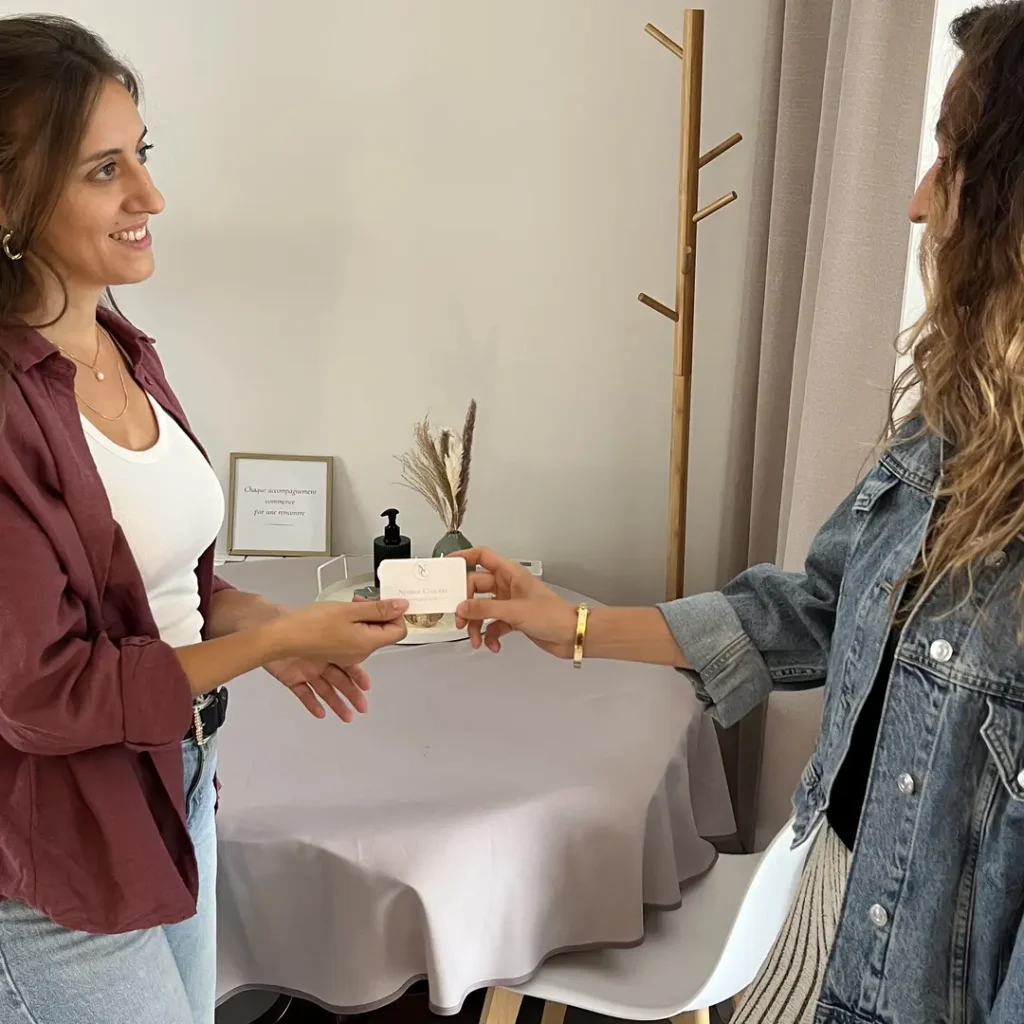 Noémie Cuquejo remettant sa carte de visite à une cliente